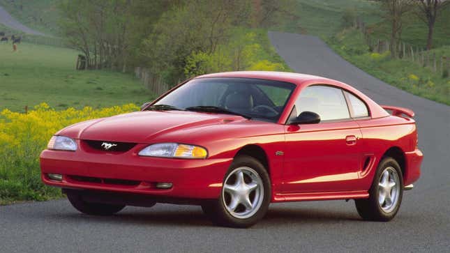 A photo of a red Ford Mustang from the 1990s. 