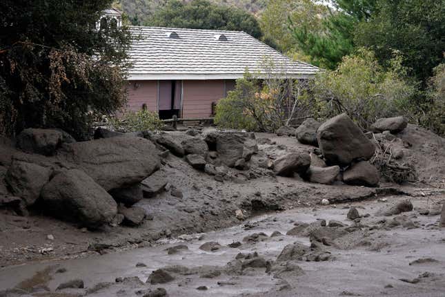 The front yard of a property is covered in mud in the aftermath of a mudslide Tuesday, Sept. 13, 2022, in Oak Glen, California.