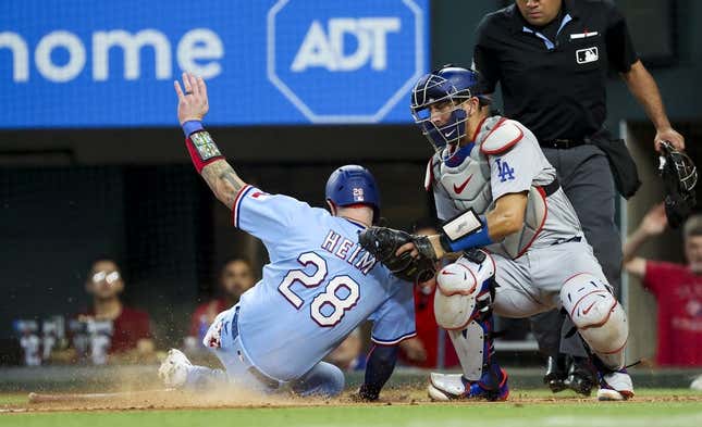 Jul 23, 2023; Arlington, Texas, USA;  Texas Rangers catcher Jonah Heim (28) scores ahead of the tag by Los Angeles Dodgers catcher Austin Barnes (15) during the fourth inning at Globe Life Field.