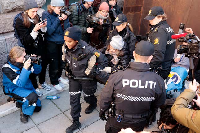 Greta Thunberg, center, is carried away by police outside the Ministry of Finance on March 1, 2023.