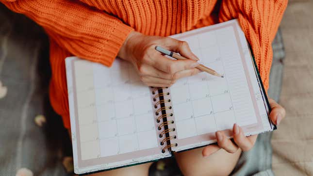woman writing in monthly planner