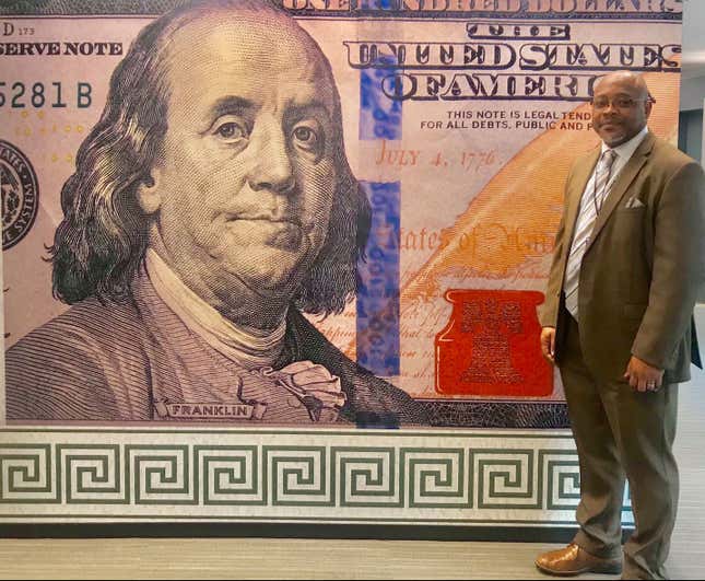 Designer Brian Thompson poses with his banknote.