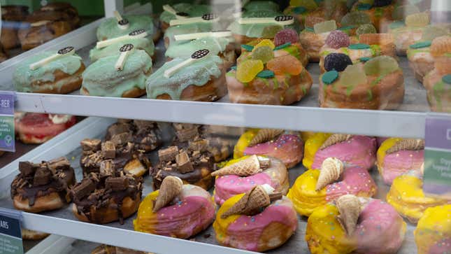 A photo of a display of iced donuts. 