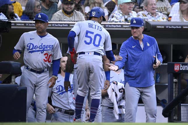 Aug 4, 2023; San Diego, California, USA; Los Angeles Dodgers right fielder Mookie Betts (50) is congratulated at the dugout after scoring a run against the San Diego Padres during the fifth inning at Petco Park.