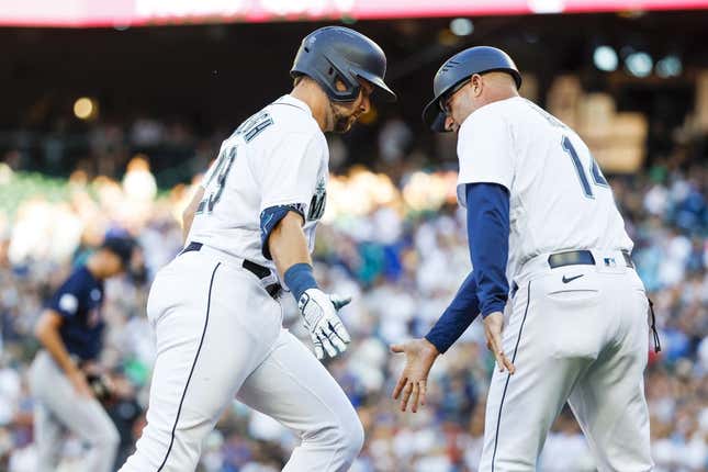 Jul 31, 2023; Seattle, Washington, USA; Seattle Mariners catcher Cal Raleigh (29) receives a greeting from third base coach Manny Acta (14) while running the bases following a solo-home run against the Boston Red Sox during the second inning at T-Mobile Park.