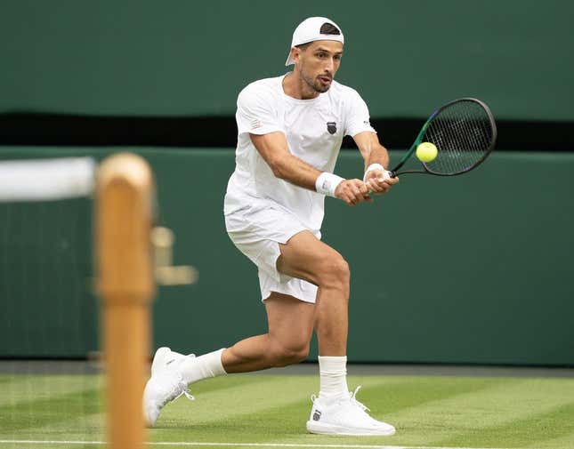 Jul 3, 2023; London, United Kingdom;  Pedro Cachin (ARG) returns the ball during his match against Novak Djokovic (SRB) on day one of the Wimbledon championships at the All England Lawn Tennis and Croquet Club.