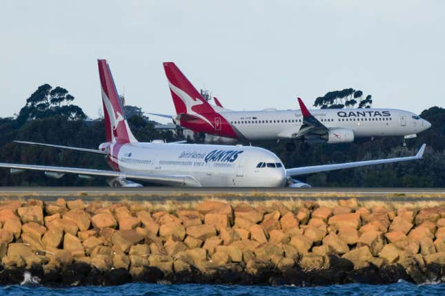 FILE - Qantas passenger jets cross as they taxi at Sydney Airport in Sydney, Australia, on Sept. 5, 2022. Australia’s consumer watchdog on Friday, Sept. 1, 2023, called for Qantas Airways to be punished with a record fine for allegedly selling tickets on thousands of flights that had already been canceled. (AP Photo/Mark Baker,File)
