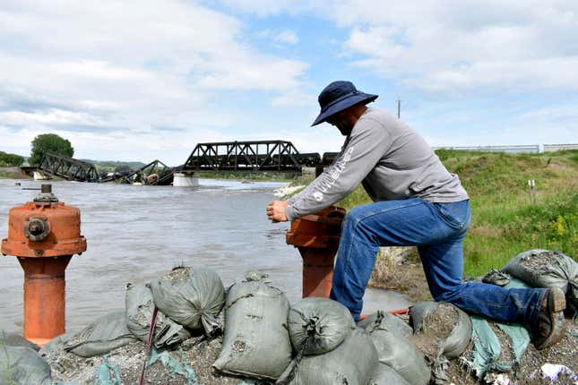 Kelly Hitchcock closes an irrigation ditch just downriver from a bridge collapse at the Yellowstone River near Columbus, Montana, on Saturday, June 24, 2023.