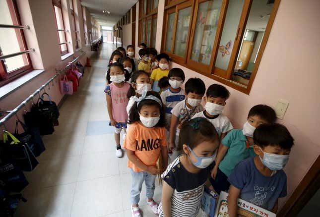 Students wait in a line outside their classroom at an elementary school in Seoul.
