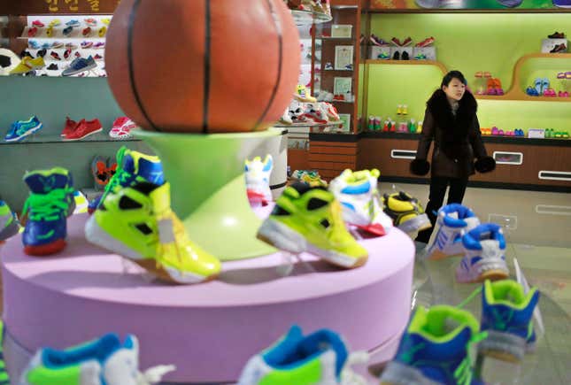 In this Friday, Feb. 1, 2019, photo, a guide stands near a basketball shoe display in a product exhibition room at the Ryuwon Shoe Factory that specializes in sports footwear, in Pyongyang, North Korea. North Korean pop culture, long dismissed by critics as a kitschy throwback to the dark days of Stalinism, is getting a major upgrade under leader Kim Jong Un. The changes are being seen in everything from television dramas and animation programs to the variety and packaging of consumer goods, which have improved significantly under Kim. (AP Photo/Dita Alangkara)