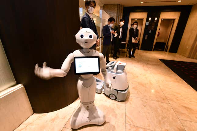  Pepper and cleaning robot Whiz are seen during a demonstration at the entrance of a hotel for patients suffering mild symptoms of covid-19 in Tokyo, Japan on April 30, 2020.