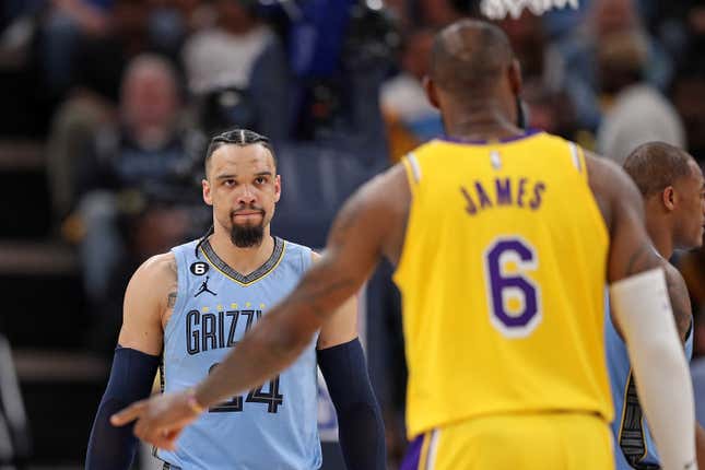 A black man with braided hair in a powder blue Memphis Grizzlies' jersey looks hard to a Black man in a yellow Lakers' jersey, whose back is to us, revealing only the number 6 and the name "James"