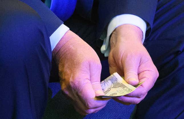 Then-President Donald Trump counts money for an offering during service at the International Church of Las Vegas in Las Vegas on October 18, 2020.