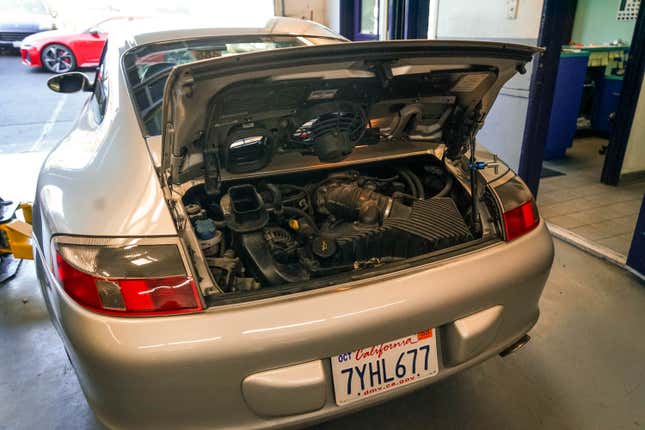 A 2003 Porsche 911 has its engine decklid open.