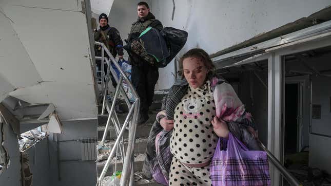 An injured pregnant woman walks downstairs in a maternity hospital  damaged by shelling in Mariupol, Ukraine, on March 9, 2022.