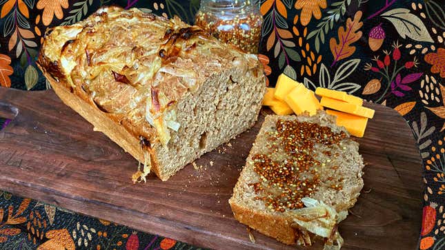 Beer bread with onions, mustard, and cheese on wooden cutting board