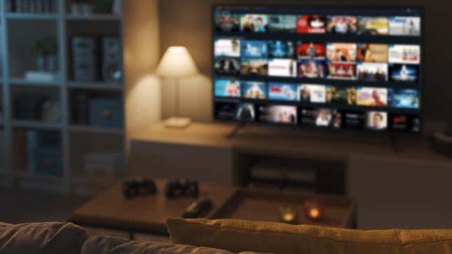 An photo of a living room with dimmed lights and an out of focus smart TV displaying various indistinguishable apps