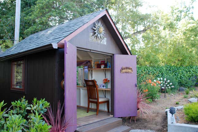 A backyard she shed with a home office inside.
