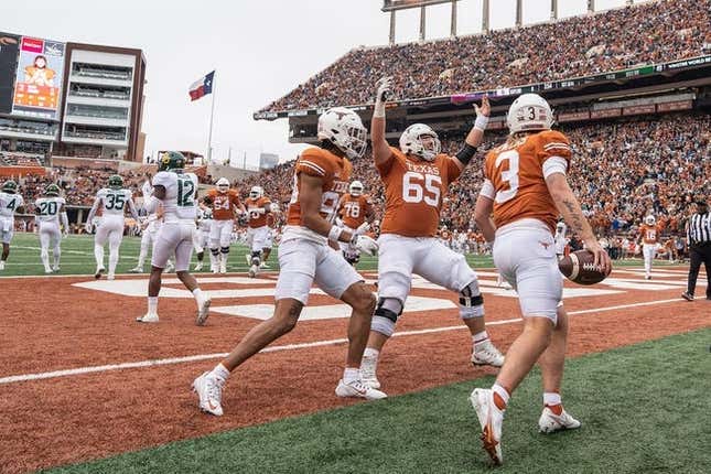 Texas Longhorns wide receiver Casey Cain (88), Texas Longhorns offensive lineman Jake Majors (65) and Texas Longhorns quarterback Quinn Ewers (3) celebrate after Ewers touch down during the Texas Longhorns game against Baylor on Friday, Nov. 25, 2022.