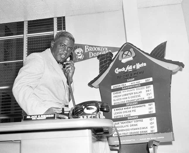 Jackie Robinson answers the phone as he began work as Vice President at Chock Full O’ Nuts company in March,1957 in New York City.