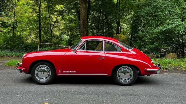 A bright red 1963 Porsche 356 Super 90 Coupe is parked in the Black Forest
