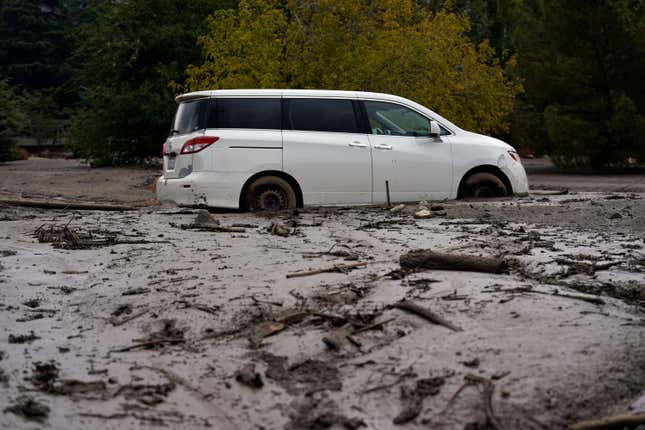 A vehicle is stuck in the mud in the aftermath of a mudslide Tuesday, Sept. 13, 2022, in Oak Glen, California.
