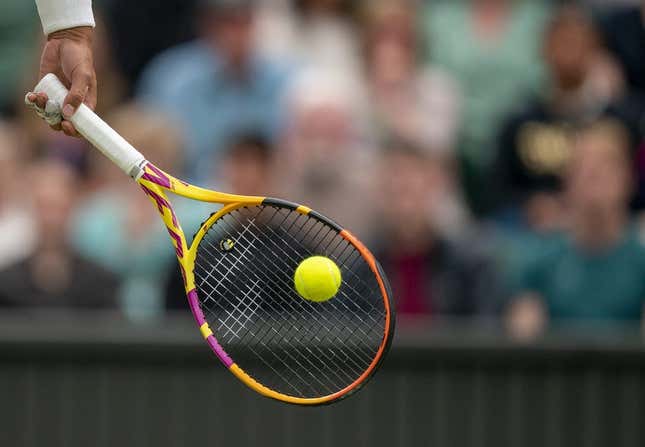 Jun 30, 2022; London, United Kingdom; A detail view of a ball on the racket of Rafael Nadal (ESP) during his match against Ricardas Berankis (LTU) on day four at All England Lawn Tennis and Croquet Club.
