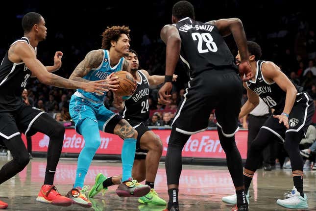 Mar 5, 2023; Brooklyn, New York, USA; Charlotte Hornets guard Kelly Oubre Jr. (12) drives to the basket against Brooklyn Nets center Nic Claxton (33) and guard Cam Thomas (24) and forward Dorian Finney-Smith (28) and guard Spencer Dinwiddie (26) during the second quarter at Barclays Center.