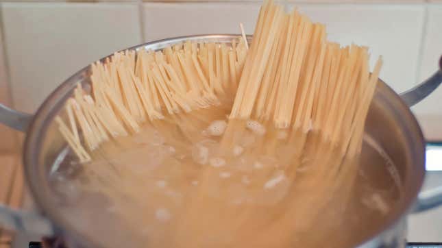 Pasta boiling in bot, uncooked ends sticking up out of the water