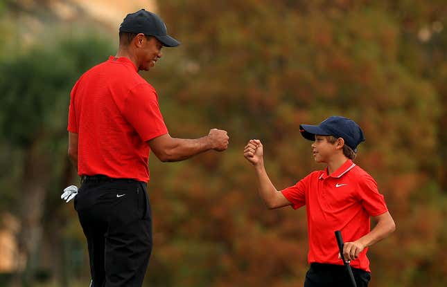  Tiger Woods of the United States and son Charlie Woods fist bump on the 18th hole during the final round of the PNC Championship at the Ritz Carlton Golf Club on December 20, 2020 in Orlando, Florida. 