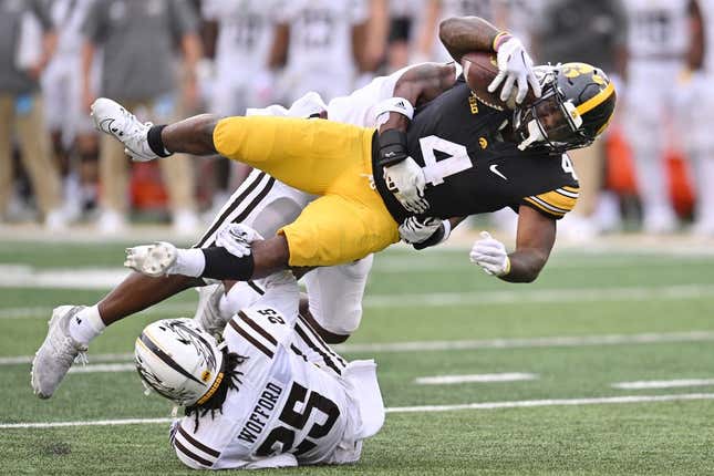 Sep 16, 2023; Iowa City, Iowa, USA; Iowa Hawkeyes running back Leshon Williams (4) runs the ball as Western Michigan Broncos cornerback Aaron Wofford (25) and linebacker Damari Roberson (rear) make the tackle during the first quarter at Kinnick Stadium.