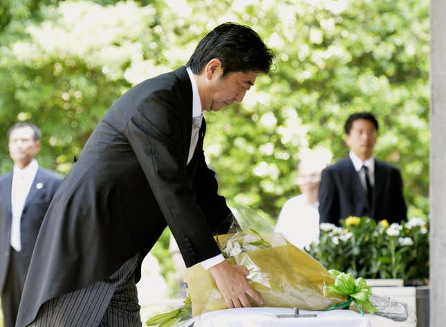 Abe offers a bouquet of flowers at Chidorigafuchi cemetery—a separate site from the controversial Yasakuni shrine.