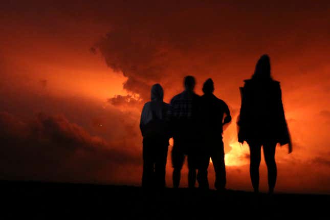 People watch Mauna Loa erupt on Monday, November 28, 2022.