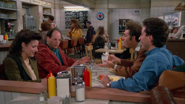 A screenshot of Seinfeld featuring the main cast around the table in Monk's Diner