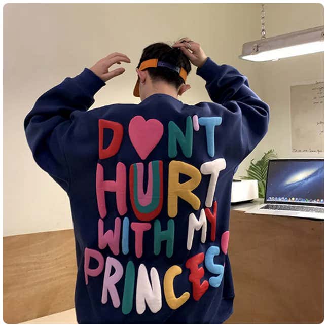 A man wearing a sweater that says "Don't hurt with my princess."