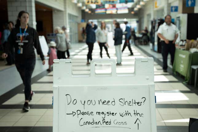 A sign directing evacuees is seen as volunteers and workers set up an evacuation centre where food and shelter is being provided for those forced from their homes due to the wildfire burning in suburban Halifax, Nova Scotia, on Tuesday, May 30, 2023. 