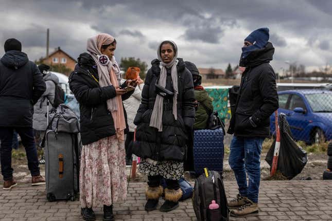 Indian girls wait for transport as refugees from many diffrent countries - from Africa, Middle East and India - mostly students of Ukrainian universities arrive at the Medyka pedestrian border crossing fleeing the conflict in Ukraine.