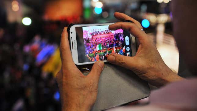 A man watches video of a sporting even on an Android smartphone