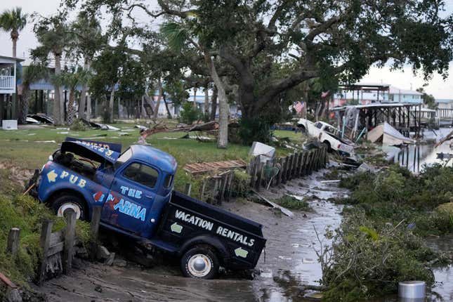 Pick up trucks and debris lie strewn in a canal in Horseshoe Beach, Florida, after the passage of Hurricane Idalia, on August 30, 2023.