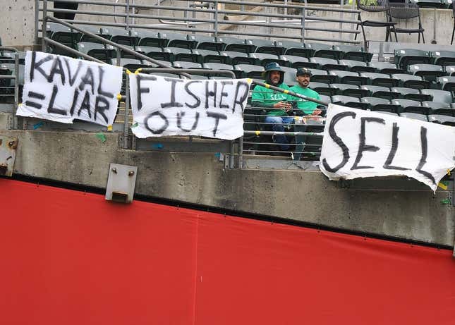 May 28, 2023; Oakland, California, USA; Oakland Athletics fans sit between signs reading  Kaval=liar ,  Fisher out  and  sell  during the first inning against the Houston Astros at Oakland-Alameda County Coliseum.