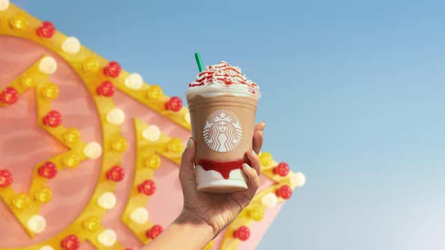 Colorful Starbucks Frappucino held up over carnival background