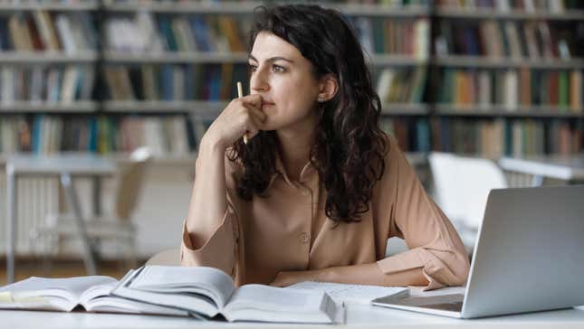 woman studying, looking off to the distance in deep thought