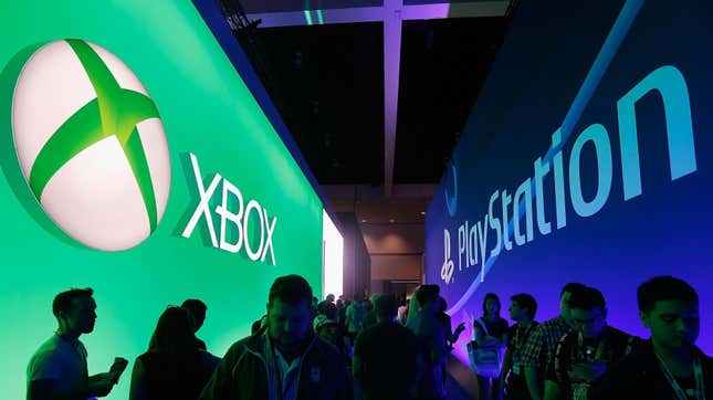 People walk through a hallway under opposing Xbox and PlayStation signage. 