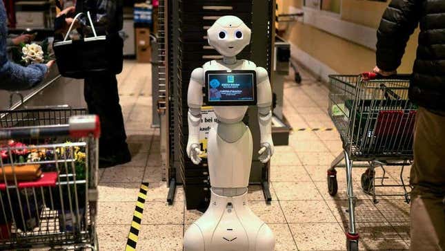 A white helper robot standing in a supermarket aisle