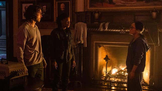 Three characters from Y: The Last Man (Yorick, Agent 355, and Dr. Mann) stand in front of a roaring fireplace.