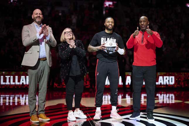 Portland Trail Blazers GM Joe Cronin, left, owner Jody Allen, and head coach Chauncey Billups stand with guard Damian Lillard (0) as he is congratulated on making the NBA All Star team before a game against the Washington Wizards at Moda Center.