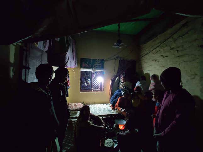 A photo of the families of those arrested huddled together in a dimly lit room.