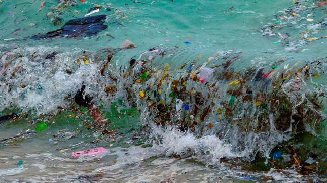A wave carrying plastic waste and other rubbish washes up on a beach in Koh Samui in the Gulf of Thailand.