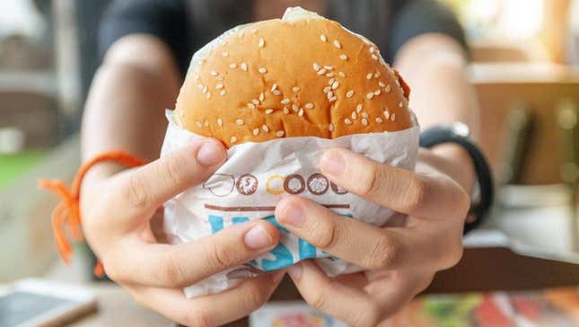 Hands holding out sandwich at Burger King in Thailand