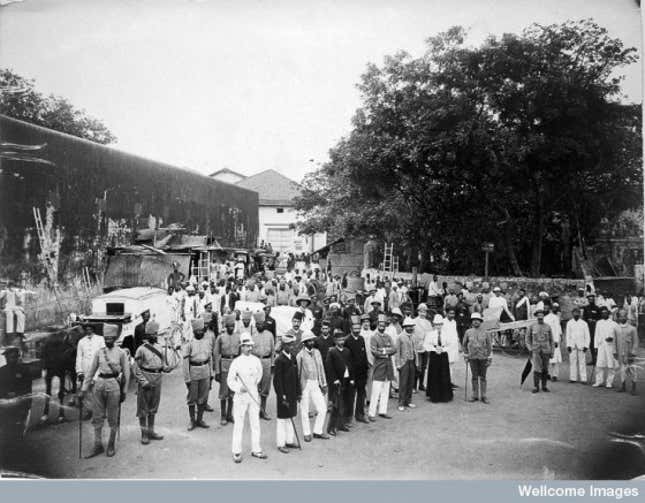 A group comprising doctors, health and public officials gathered on a street in Bombay about to begin the day’s work, during an outbreak of plague.